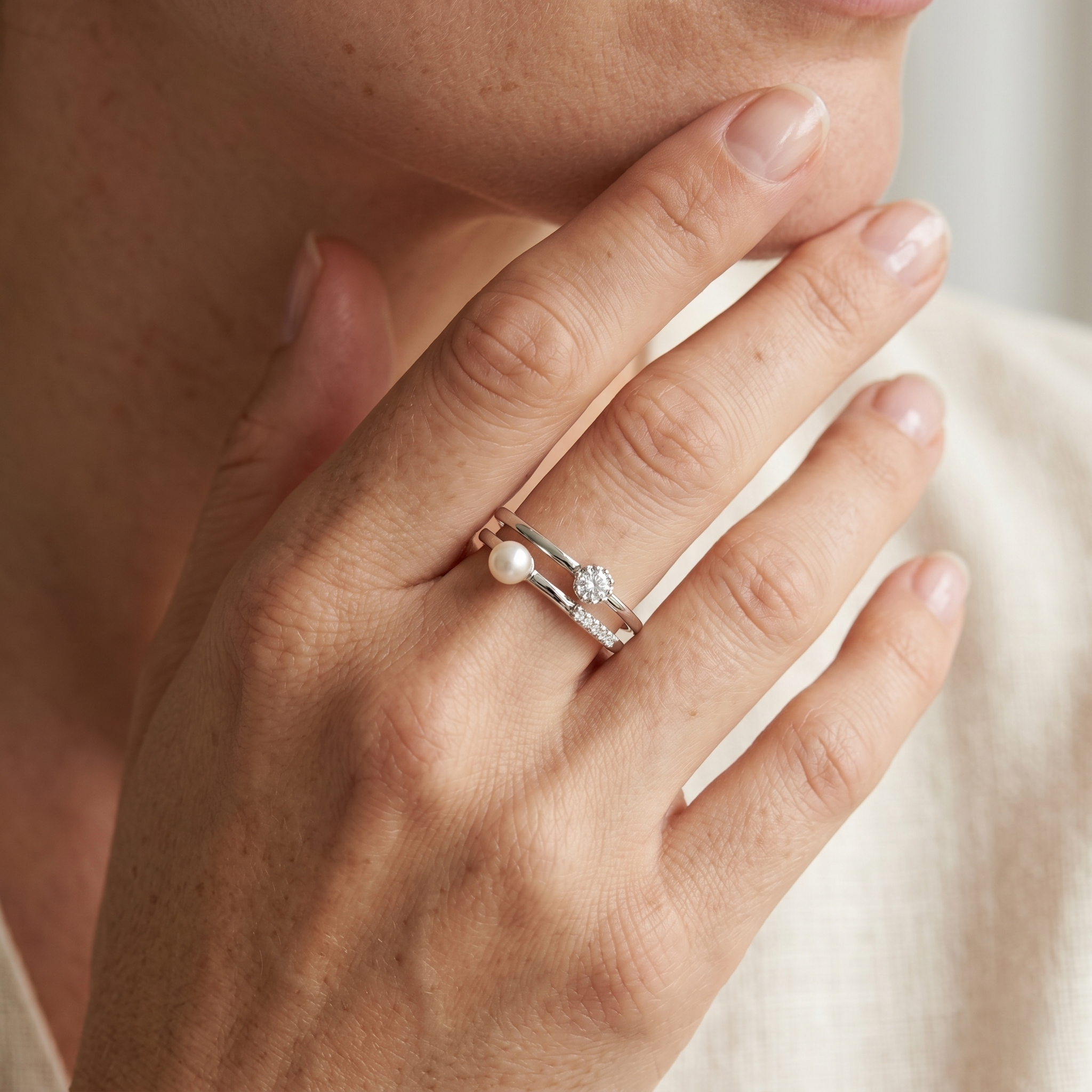 Anillo delicado de plata 925 con detalle perlado y brillante llevado en la mano