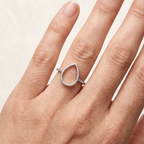 Anillo con silueta de gota abierta sobre mano