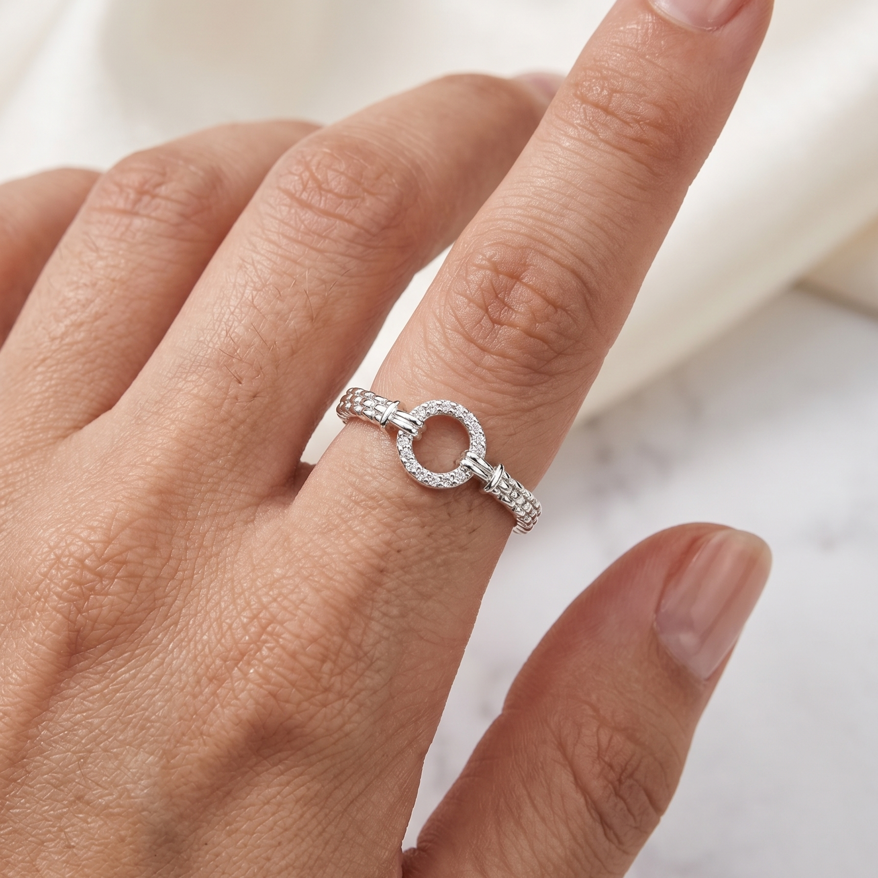 Anillo fino de plata 925 con motivo circular y detalles laterales texturizados