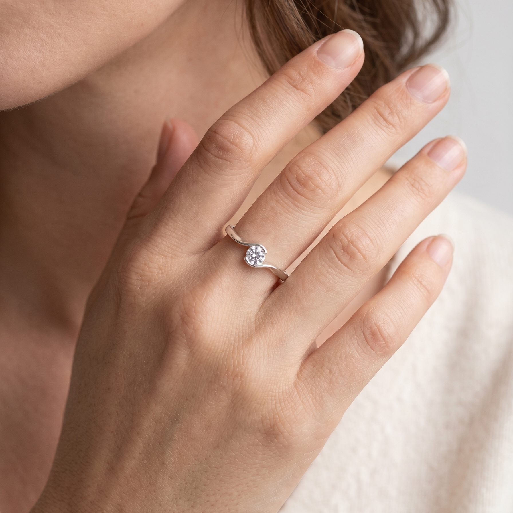 Anillo delicado de plata 925 con diseño curvo y piedra brillante llevado en la mano