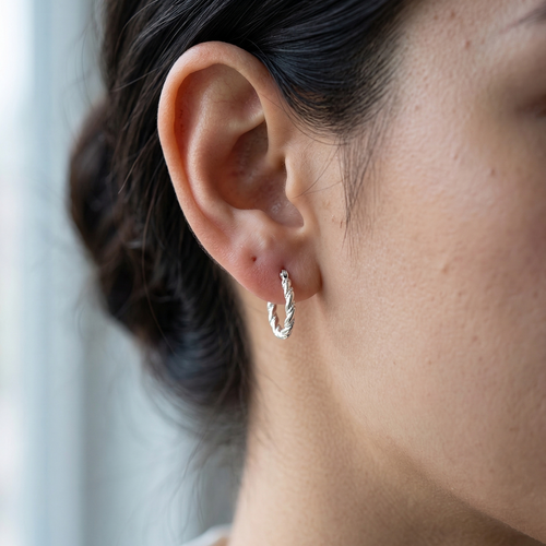 Mujer usando aretes argolla trenzada de plata 925 pequeños