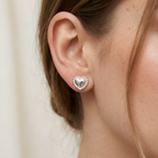 Mujer usando aretes pequeños de corazón perlado en plata 925