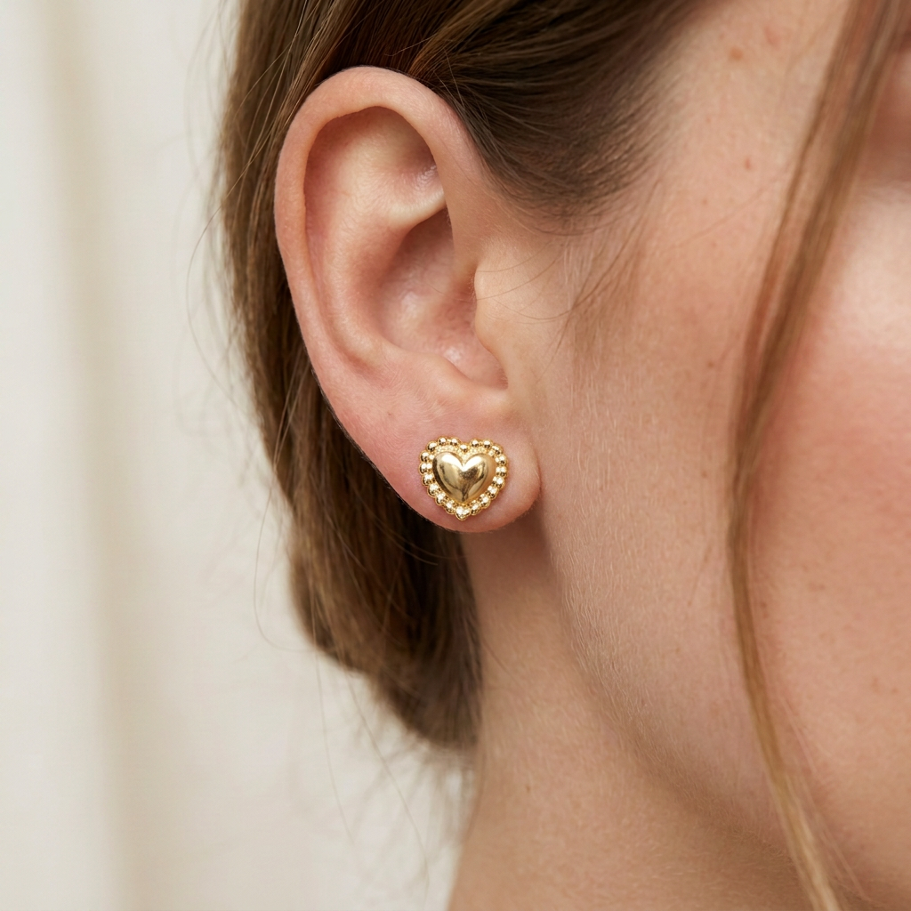 Mujer usando aretes pequeños de corazón perlado en plata 925 baño oro 18K