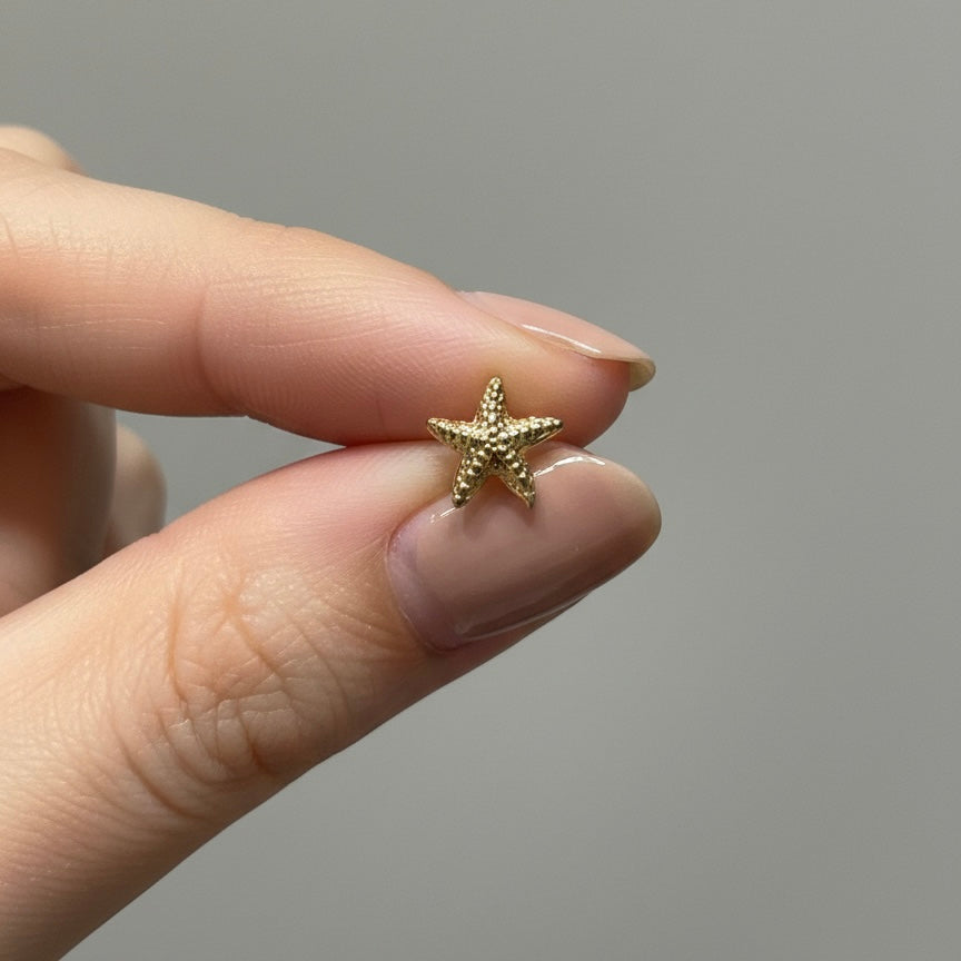 Arete estrella de mar mini dorado con diseño texturizado