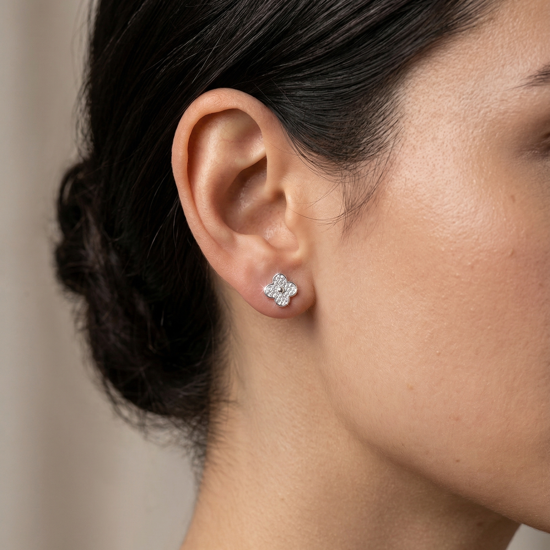 Mujer usando aretes trébol brillante de plata 925 de 1 cm