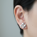 Aretes trébol de cuatro hojas de plata 925 puestos en la oreja