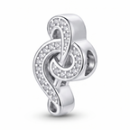Charm clave de sol de plata 925 con detalles brillantes sobre fondo blanco