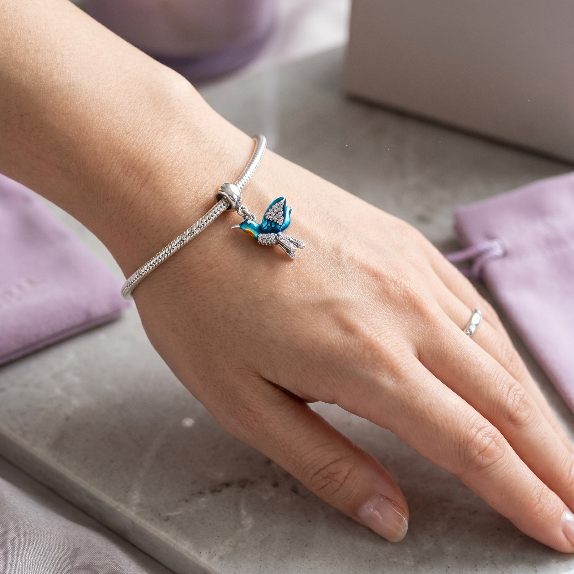Charm de plata 925 con diseño de colibrí sobre pulsera tipo charm