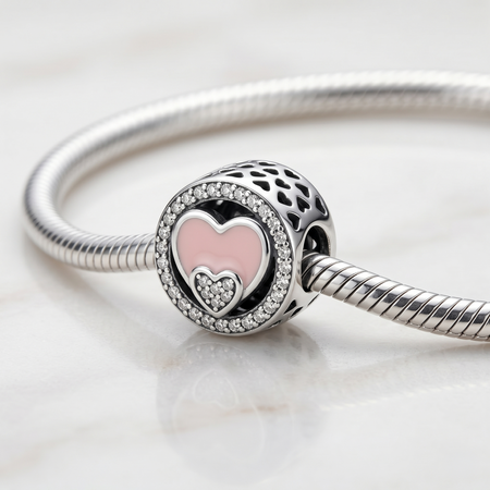 Detalle lateral de charm redondo de plata 925 con diseño romántico de corazones