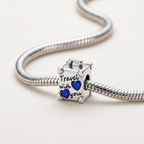 Charm de plata 925 en forma de maleta con frase Travel with you azul montado en pulsera