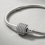 Detalle de cierre cilíndrico brillante en pulsera charms de plata 925