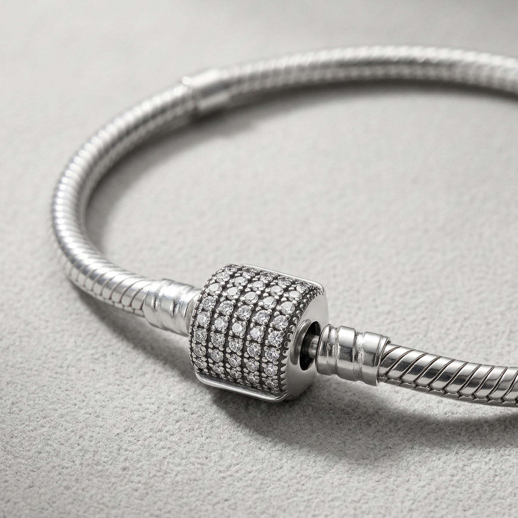 Detalle de cierre cilíndrico brillante en pulsera charms de plata 925