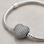 Detalle de cierre corazón brillante en pulsera charms de plata 925