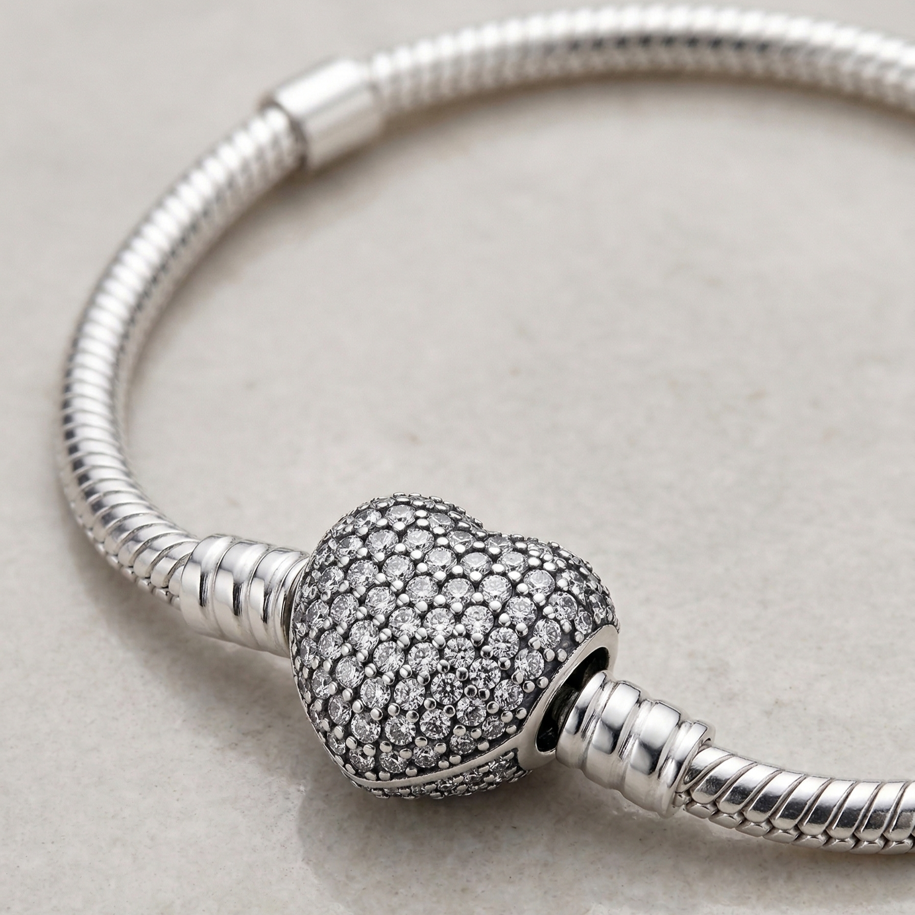 Detalle de cierre corazón brillante en pulsera charms de plata 925