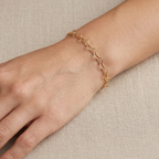 Mujer usando pulsera dorada de corazones de plata 925