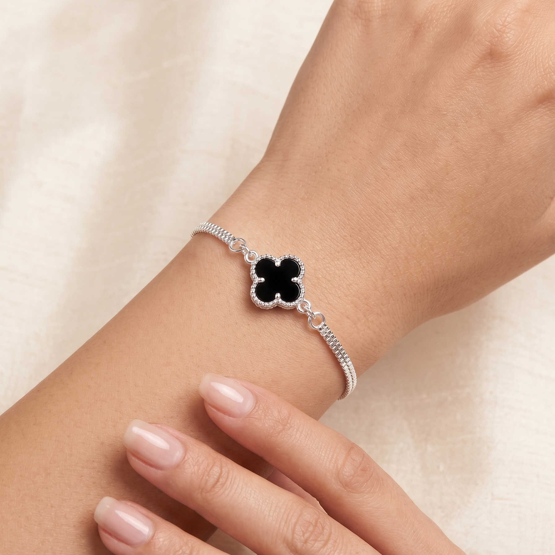 Pulsera fina de plata 925 con flor negra central sobre muñeca
