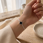 Una pulsera delicada y elegante que resalta por su contraste sutil y su detalle floral negro sofisticado.