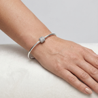 Pulsera rígida de plata 925 con charm central brillante puesta en la muñeca