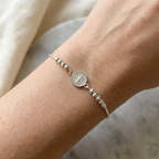 Pulsera ajustable de plata 925 con medalla San Benito usada en la muñeca