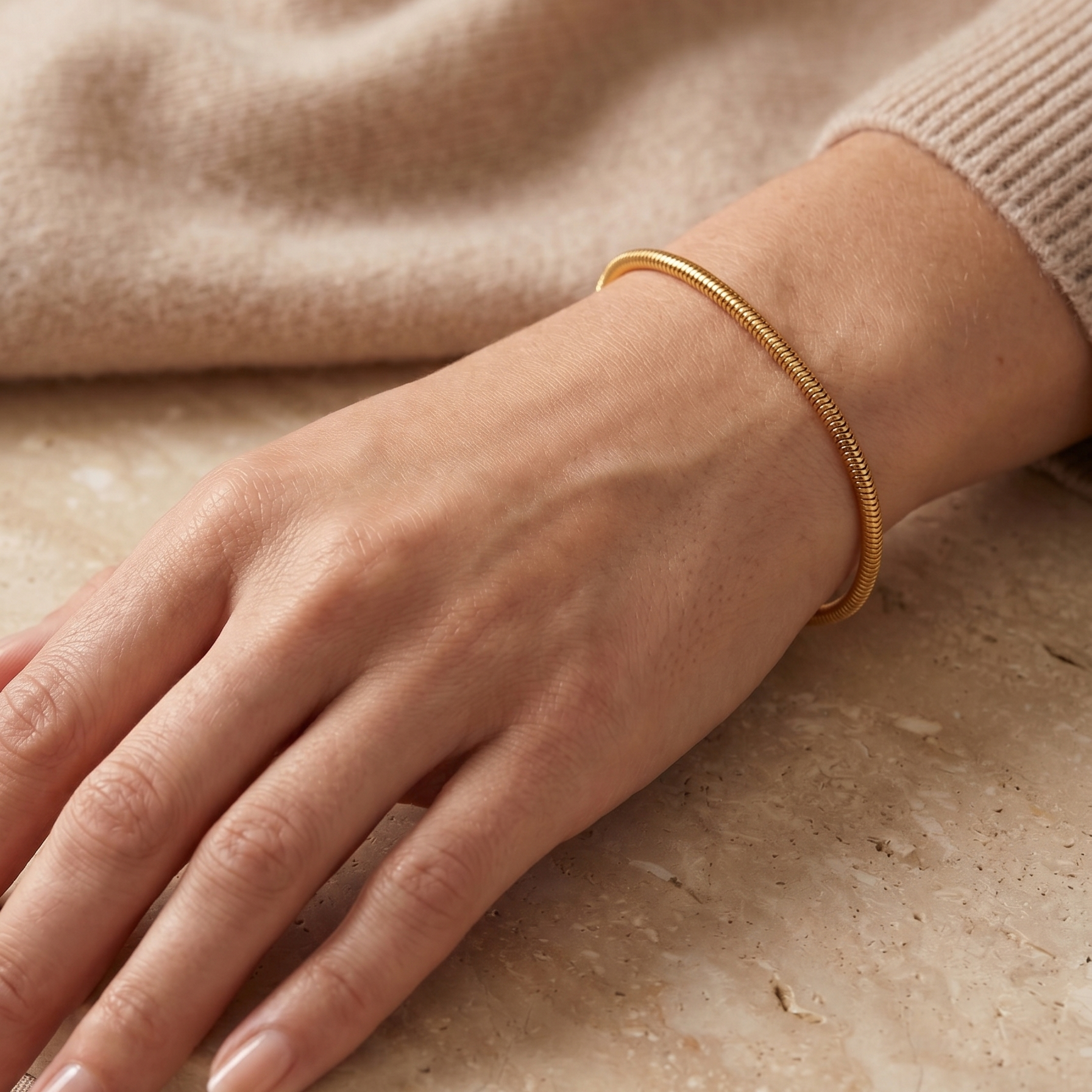 Pulsera fina de plata 925 bañada en oro de 18K sobre muñeca con diseño minimalista