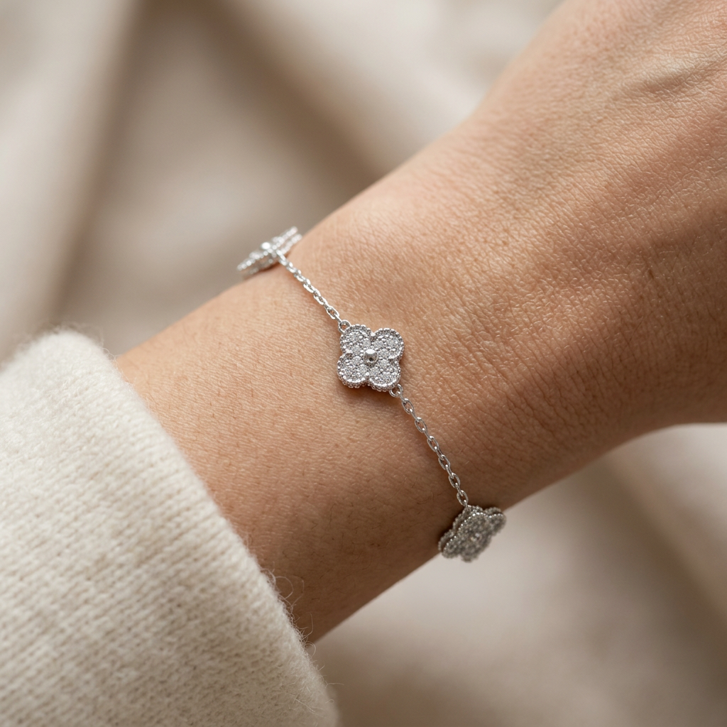 Detalle de pulsera de plata 925 con dijes tipo trébol y acabado brillante