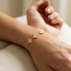 Pulsera ajustable de plata 925 bañada en oro de 18K con tres flores sobre muñeca